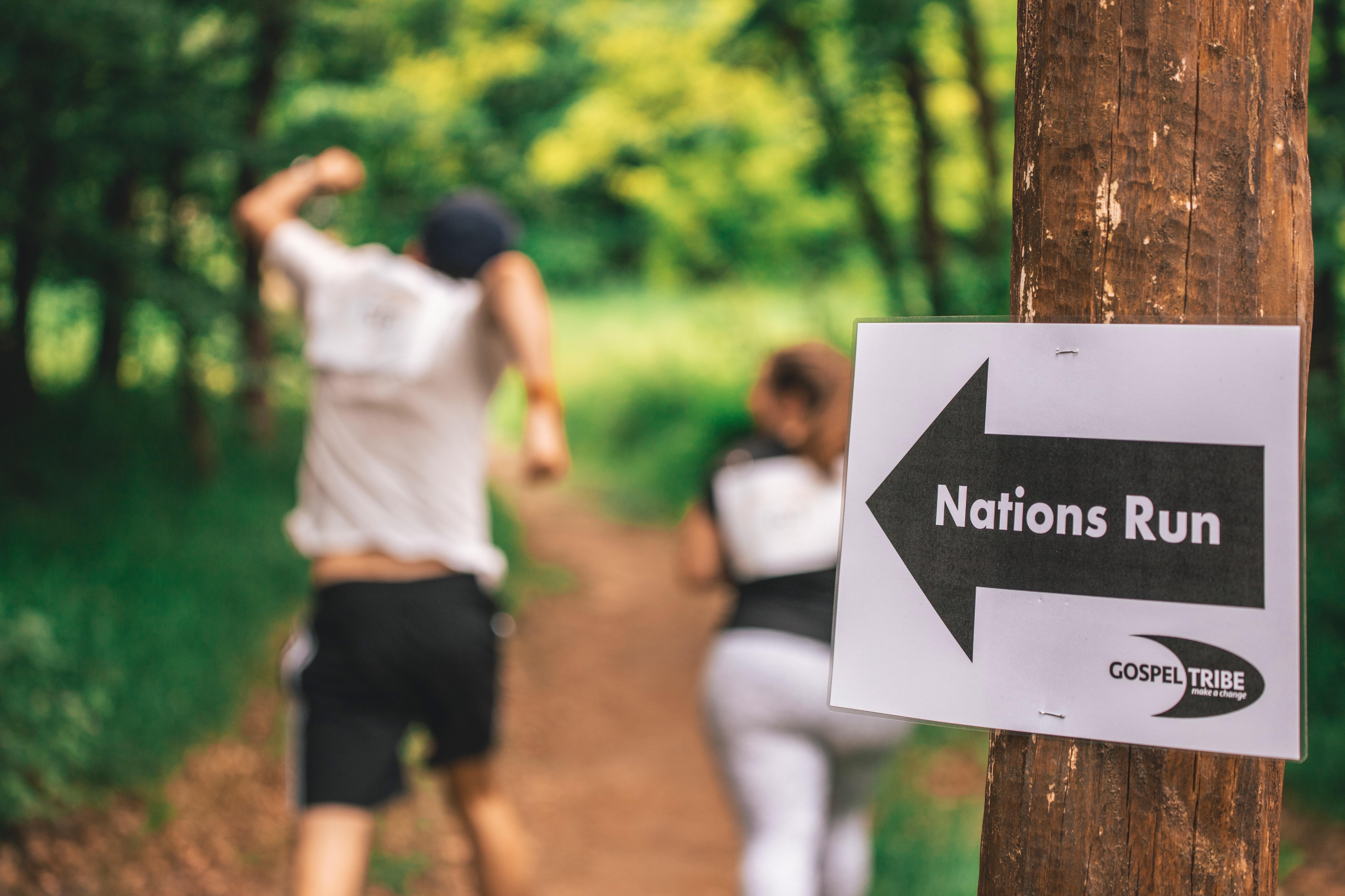 Nations Run Schild im vordergrund, 2 Läufer im Hintergrund

